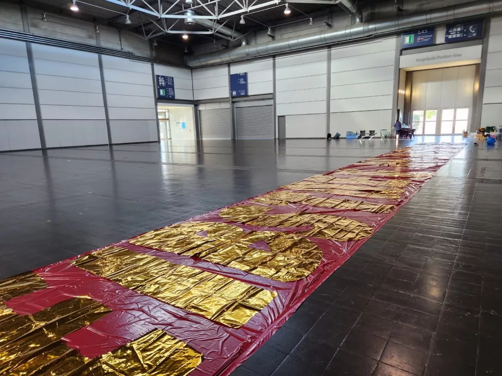 Auch das Spruchband bekam seine goldene Wirkung: ein langer, kleinteiliger Arbeitsschritt für die klare Botschaft unter der Choreo.